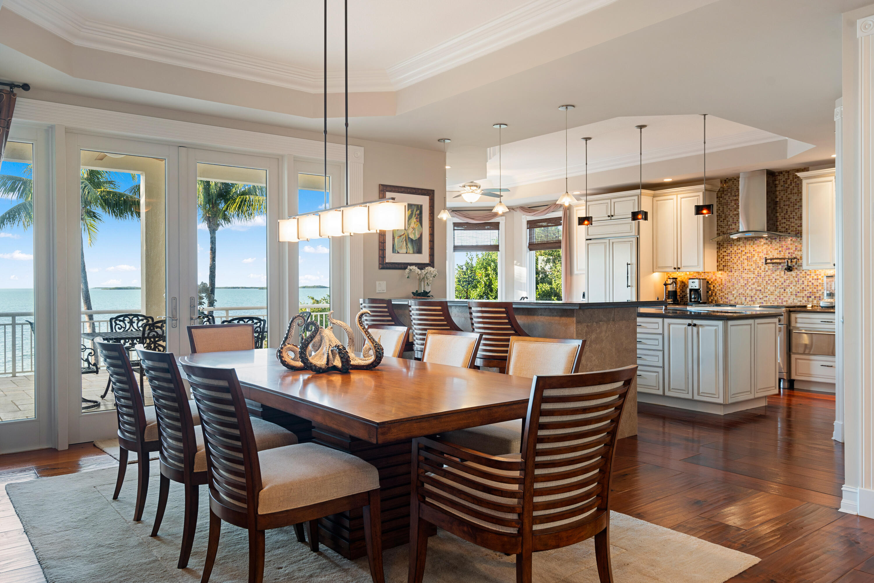 104 Coastal Drive Key Largo, FL 33037 - Photo 15 of 77 a dining room with furniture a chandelier and wooden floor