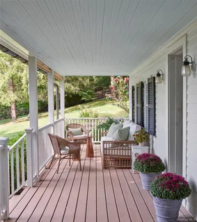a view of a balcony with chairs and wooden floor