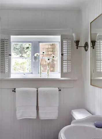 a bathroom with a toilet sink and window