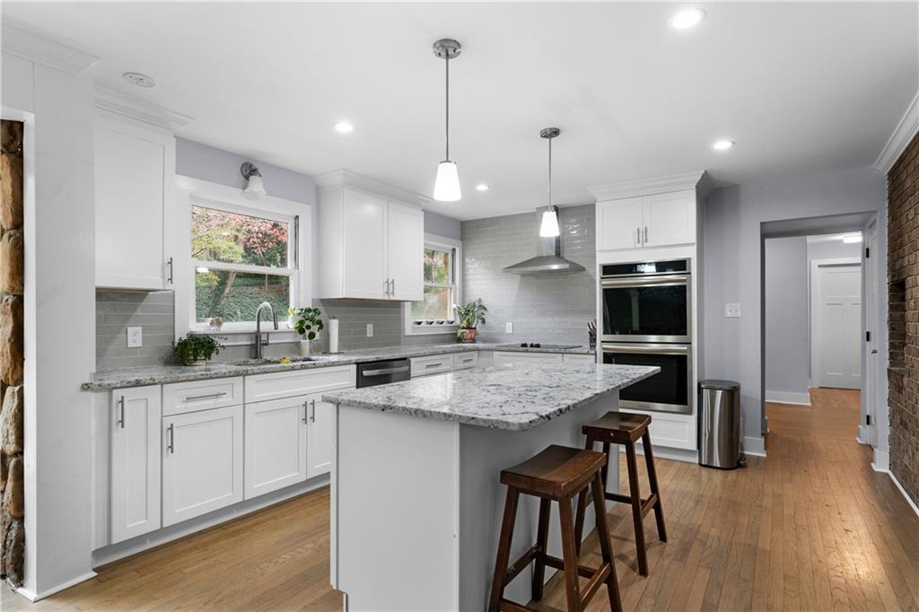 12 Allison Circle Cartersville, GA 30120 - Photo 14 of 35 a kitchen with stainless steel appliances granite countertop a stove top oven a sink a refrigerator a dining table and chairs with wooden floor