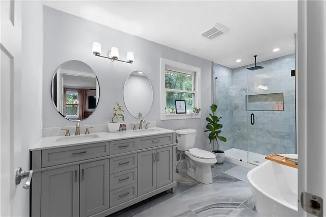 a bathroom with a double vanity sink toilet and a mirror