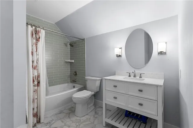 a bathroom with a toilet a sink a mirror a bathtub and vanity