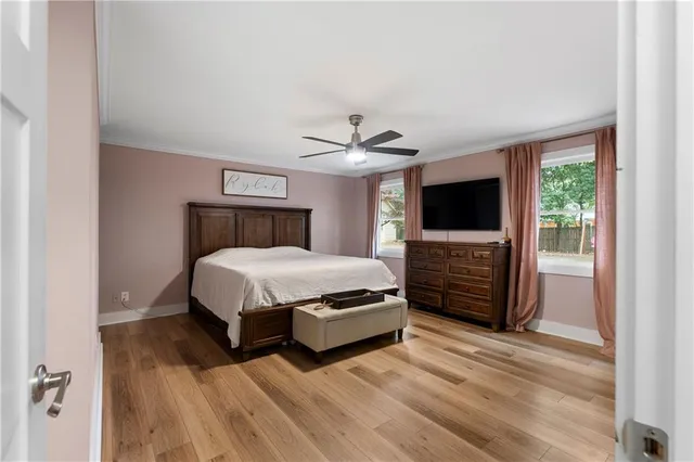 a spacious bedroom with a bed and a flat screen tv