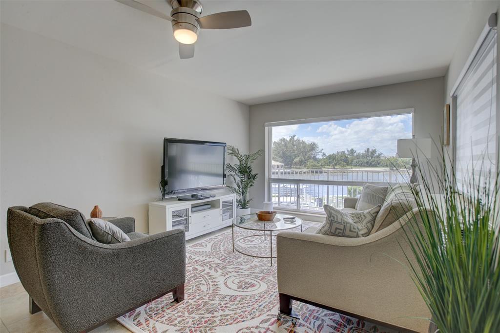 999 North Riverside Drive, Unit 10 Pompano Beach, FL 33062 - Photo 5 of 14 a living room with furniture large window and flat screen tv