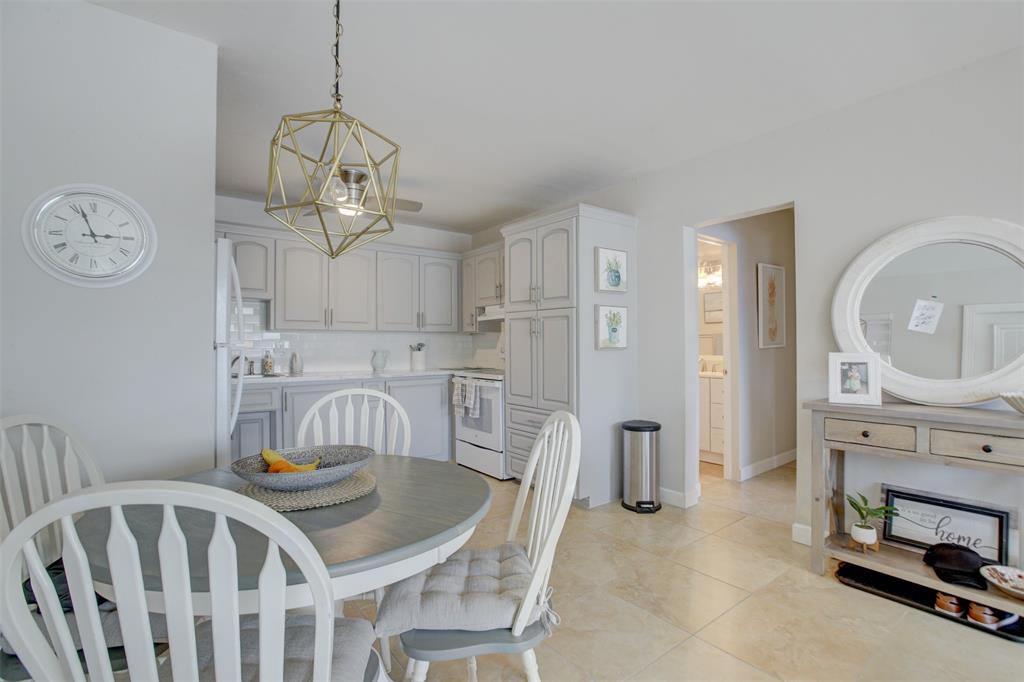 999 North Riverside Drive, Unit 10 Pompano Beach, FL 33062 - Photo 7 of 14 a view of a dining room with furniture a chandelier and wooden floor