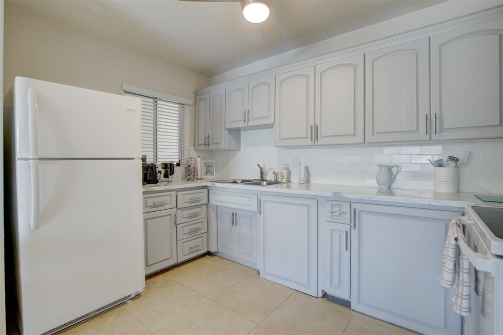 999 North Riverside Drive, Unit 10 Pompano Beach, FL 33062 - Photo 8 of 14 a kitchen with white cabinets and white appliances