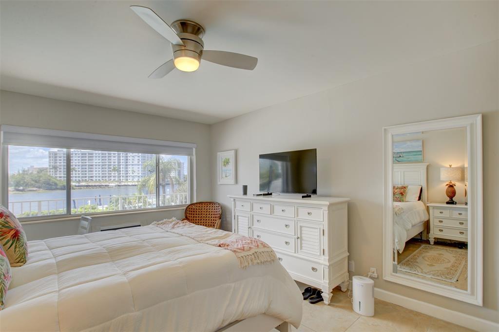 999 North Riverside Drive, Unit 10 Pompano Beach, FL 33062 - Photo 10 of 14 a bedroom with a bed and flat screen tv