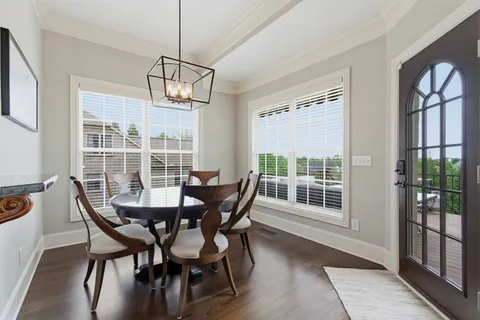 a view of a dining room with furniture large windows and wooden floor