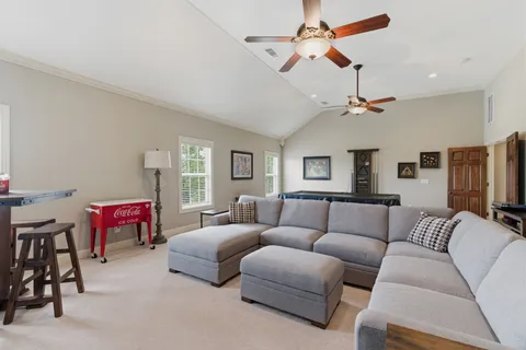 a living room with furniture a chandelier and a flat screen tv