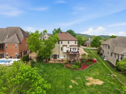 an aerial view of residential houses with outdoor space and trees