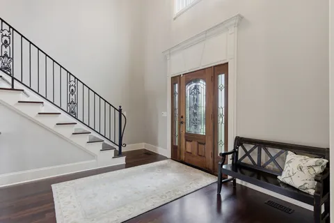 a view of a hallway with wooden floor and stairs