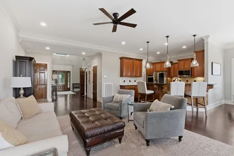 a living room with furniture kitchen view and a chandelier