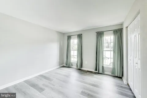 an empty room with windows and closet