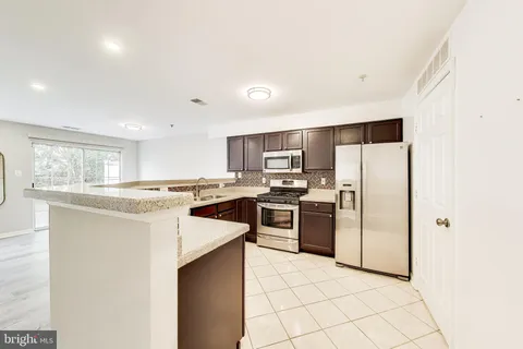 a kitchen with stainless steel appliances a refrigerator sink and stove