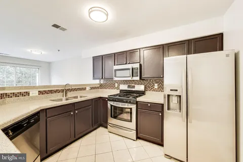 a kitchen with stainless steel appliances a sink cabinets and a refrigerator
