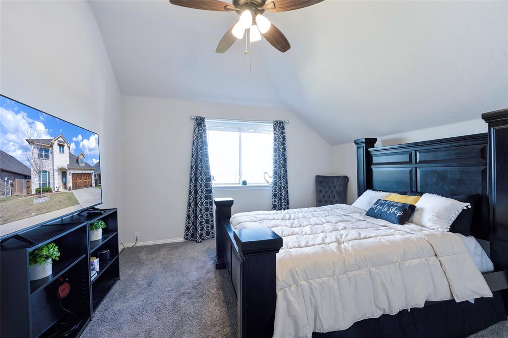 4059 Three Forks Road Kaufman, TX 75142 - Photo 22 of 25 a bedroom with a bed and a chandelier