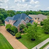 an aerial view of residential houses with outdoor space and trees