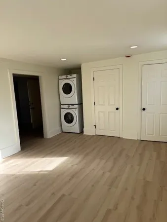 a view of an empty room with wooden floor and closet