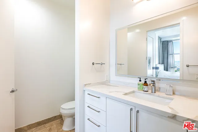 a bathroom with a sink a toilet and a large mirror