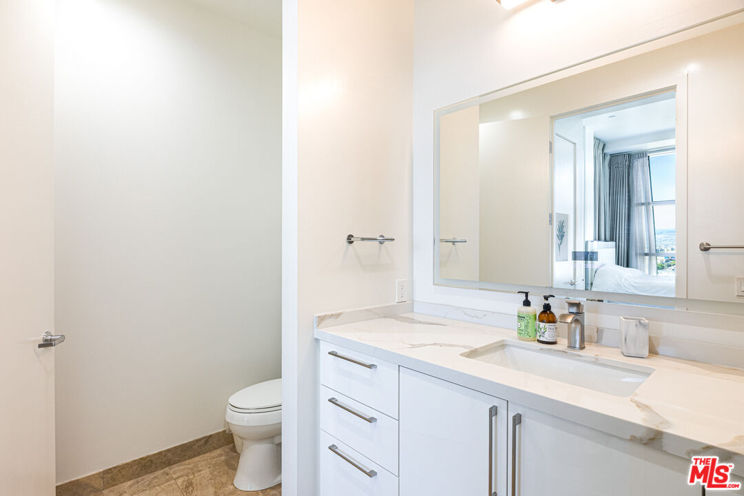 3223 West 6th Street, Unit 902 Los Angeles, CA 90020 - Photo 13 of 19 a bathroom with a sink a toilet and a large mirror