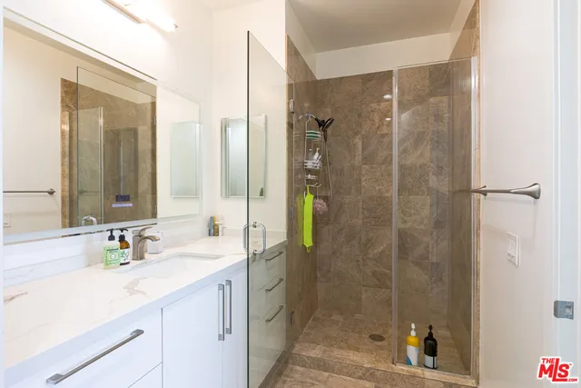 a bathroom with a shower sink and mirror