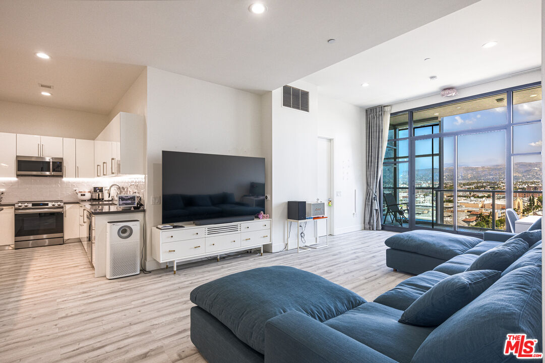 3223 West 6th Street, Unit 902 Los Angeles, CA 90020 - Photo 3 of 19 a living room with furniture and a flat screen tv
