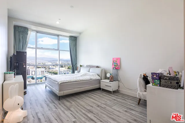 a spacious bedroom with a bed and a large window