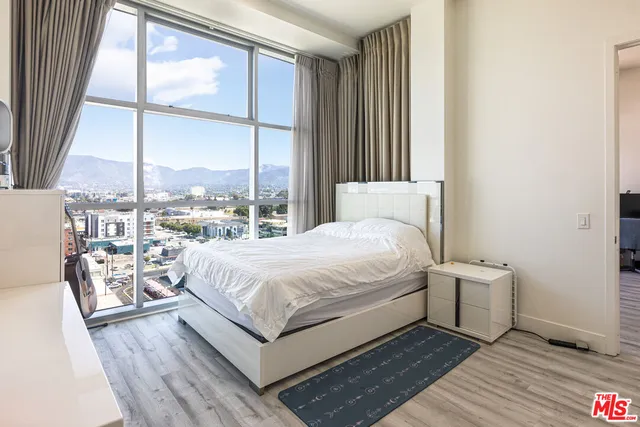 a bedroom with a bed and a large window