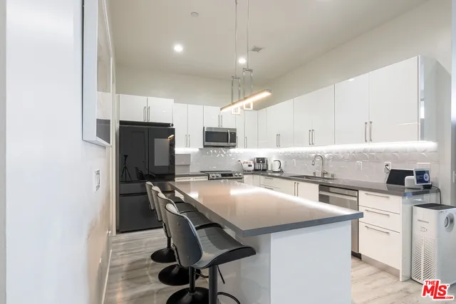 a kitchen with refrigerator a sink and chairs