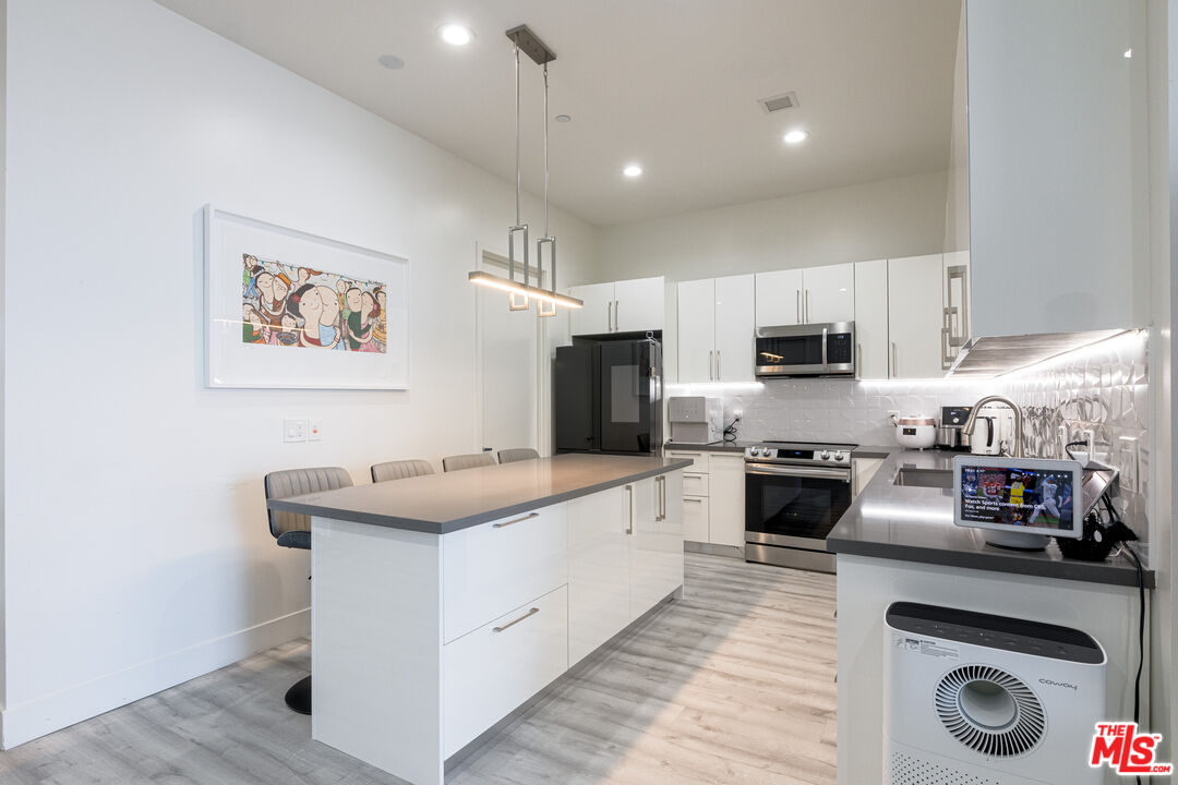3223 West 6th Street, Unit 902 Los Angeles, CA 90020 - Photo 9 of 19 a kitchen with stainless steel appliances granite countertop a sink stove and refrigerator