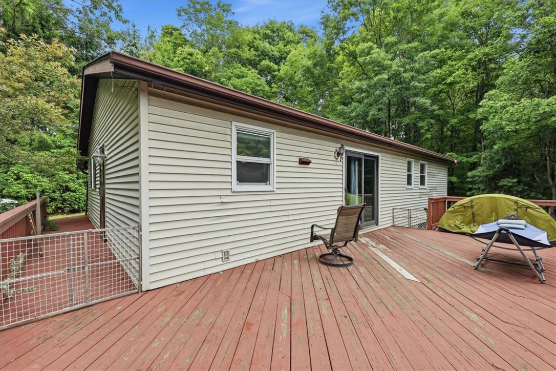 520 Highland Hill Road Jim Thorpe, PA 18235 - Photo 56 of 83 An inviting deck extends from the home's siding, providing a serene outdoor living space surrounded by natural foliage.