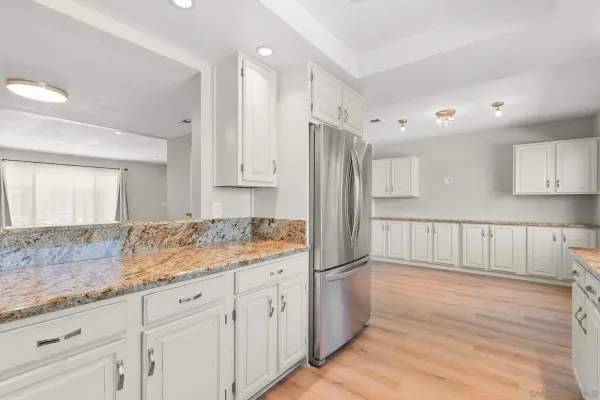 a kitchen with granite countertop white cabinets white appliances and granite counter tops