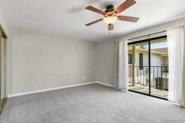 an empty room with closet and a chandelier fan