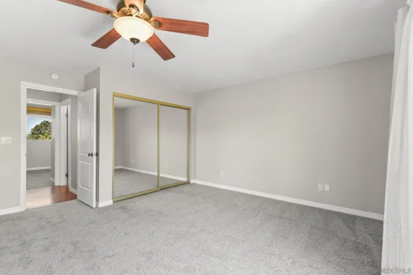 a view of an empty room with a ceiling fan