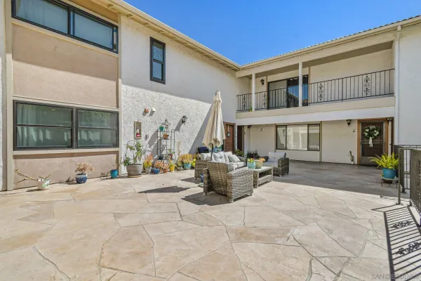 a view of a patio with couches table and chairs and potted plants