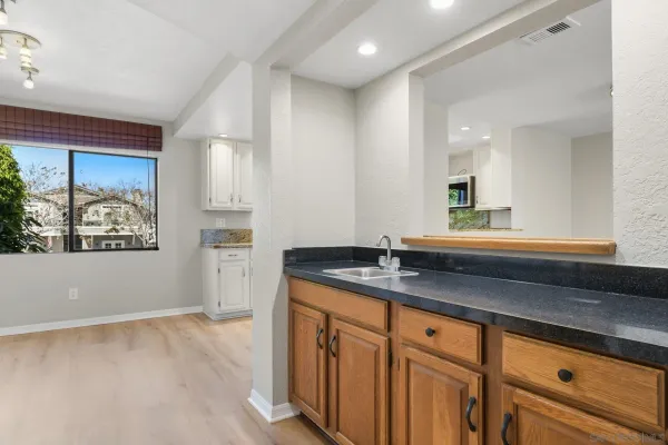 a bathroom with a granite countertop sink mirror and window