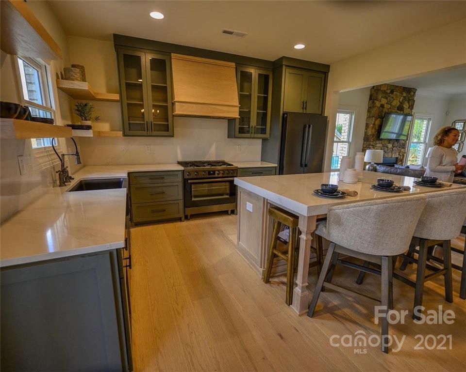 3405 Sincerity Road, Unit 14 Monroe, NC 28110 - Photo 5 of 11 a kitchen with stainless steel appliances granite countertop a sink a stove a refrigerator a dining table and chairs with wooden floor