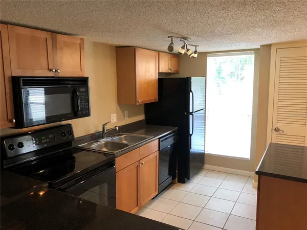 a kitchen with granite countertop a stove and a refrigerator