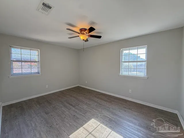 wooden floor in an empty room with a window