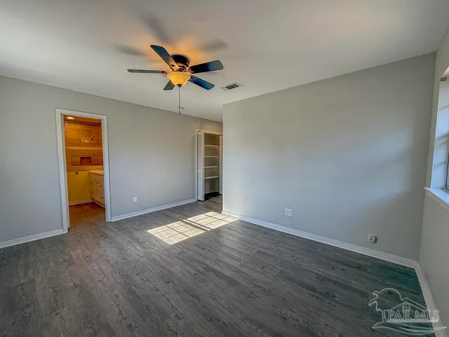 a view of a livingroom with a ceiling fan wooden floor and a ceiling fan
