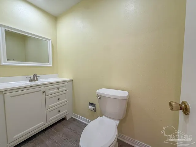 a bathroom with a toilet a sink a mirror and vanity