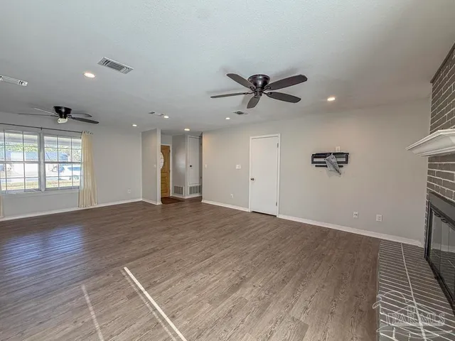a view of an empty room with a window and a ceiling fan