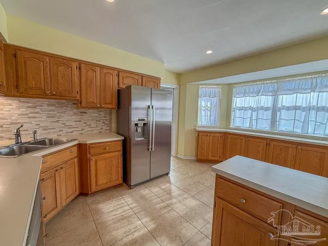 a kitchen with stainless steel appliances granite countertop a refrigerator and a sink