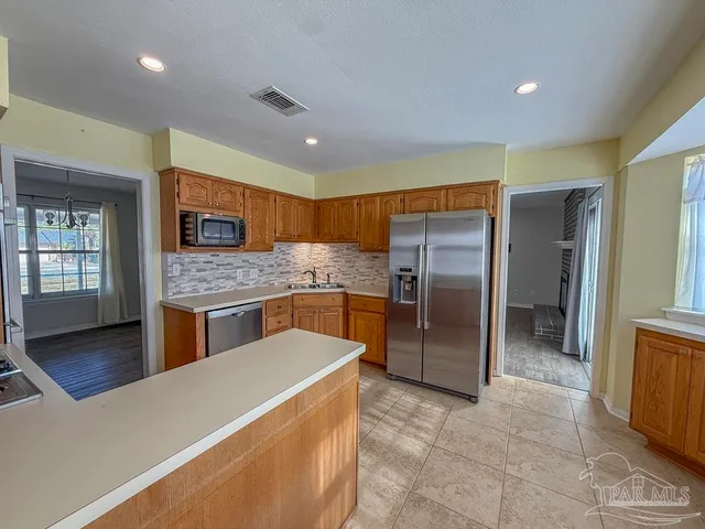 a kitchen with stainless steel appliances granite countertop a refrigerator and a stove
