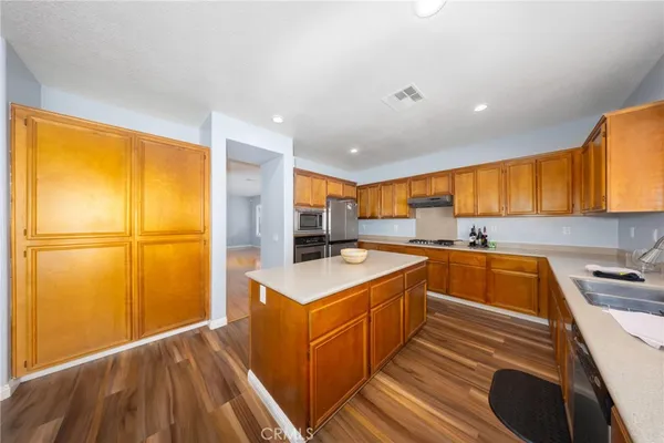 a kitchen with stainless steel appliances granite countertop a sink a stove and a refrigerator