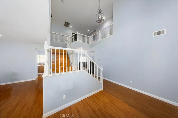 a view of a hallway with wooden floor and chandelier