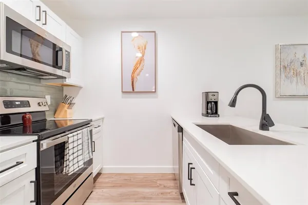 a kitchen with stainless steel appliances granite countertop a sink and dishwasher a stove with wooden floor