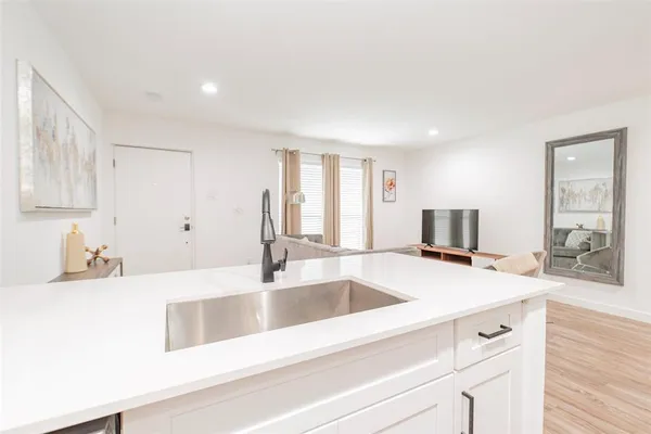 a view with granite countertop a sink and a wooden floor next to a large window