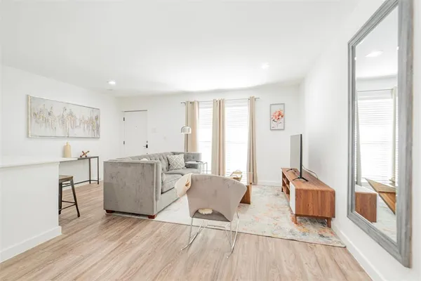 a living room with furniture and a wooden floor