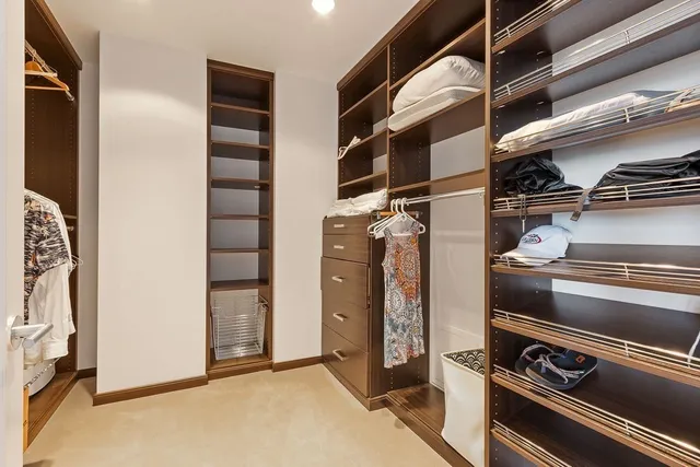 a view of walk in closet with clothes and shoes